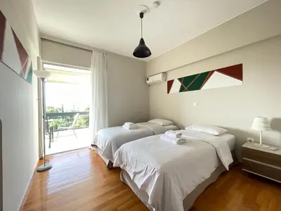 two beds in a room with a window at Archer - Sea view apartment in Athens