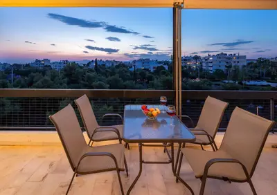 a dining room table with chairs and a view of the city at Archer - Sea view apartment in Athens