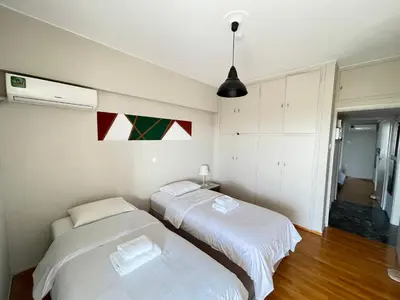 two beds in a room with white sheets at Archer - Sea view apartment in Athens