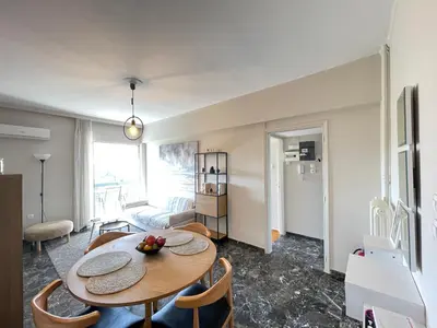 a living room with a table and chairs and a couch at Archer - Sea view apartment in Athens