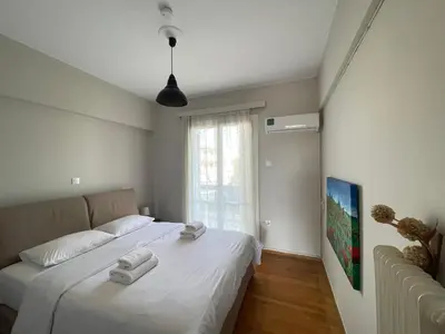a bedroom with a bed with two towels on it at Archer - Sea view apartment in Athens