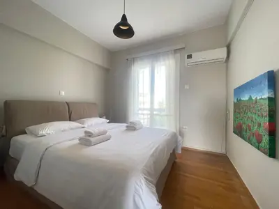 a bedroom with a white bed with towels on it at Archer - Sea view apartment in Athens