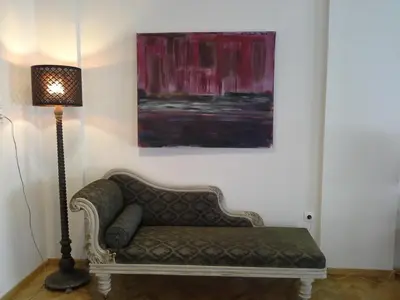 a couch in a room with a lamp and a painting at Apartment near the Beach in Athens