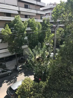 an overhead view of a parking lot with trees and a building at Apartment near the Beach in Athens
