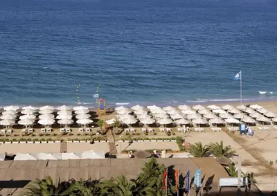 a beach with a bunch of white umbrellas and the ocean at Apartment near the Beach in Athens
