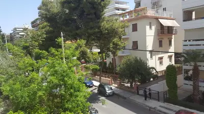 an apartment building with a car parked on the street at Apartment near the Beach in Athens