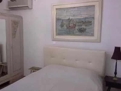a bedroom with a bed and a painting on the wall at Apartment near the Beach in Athens