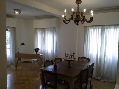 a dining room with a table and a chandelier at Apartment near the Beach in Athens