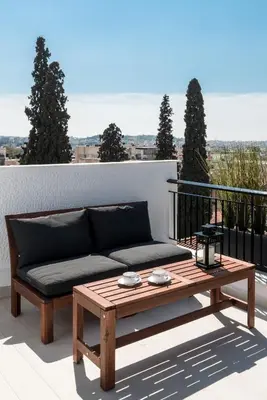 a couch and a coffee table on a balcony at Executive 2 bdr Suite in Plaka - Acropolis view in Athens