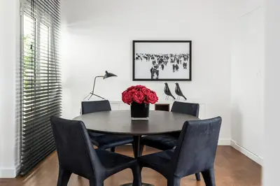 a dining room table with chairs and a vase of roses at Executive 2 bdr Suite in Plaka - Acropolis view in Athens