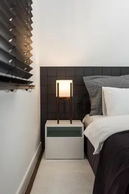 a bedroom with a bed and a lamp on a night stand at Executive 2 bdr Suite in Plaka - Acropolis view in Athens