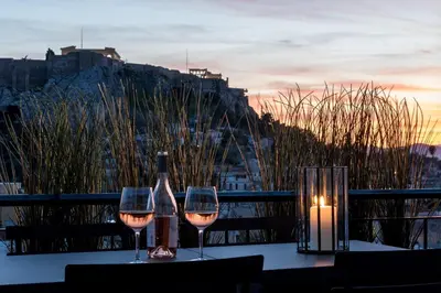 a table with two glasses of wine and a candle at Executive 2 bdr Suite in Plaka - Acropolis view in Athens