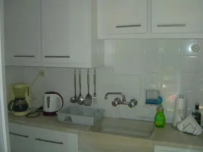 a kitchen with white cabinets and a sink with utensils at Medea in Athens