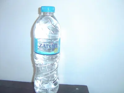 a bottle of water sitting on a table at Medea in Athens