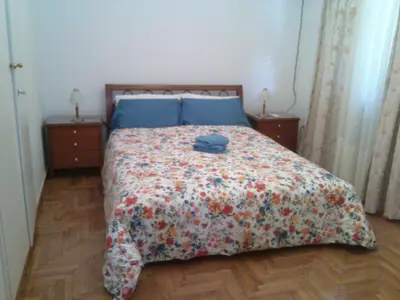 a bedroom with a bed with a blanket and two night stands at Medea in Athens