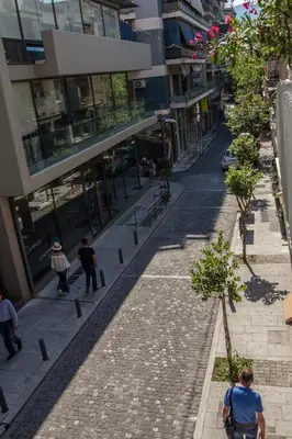 a city street with people walking down a street at Acropolis Museum - Modern Living [I] in Athens