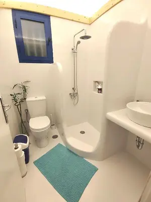 a white bathroom with a toilet and a sink at Oneiro glico in Agia Marina Aegina