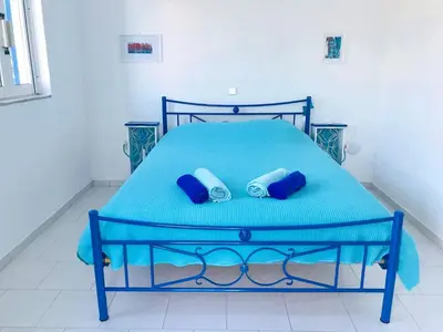 a blue bed with two blue pillows on it at Oneiro glico in Agia Marina Aegina
