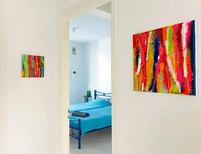 a room with a bed and two paintings on the wall at Oneiro glico in Agia Marina Aegina