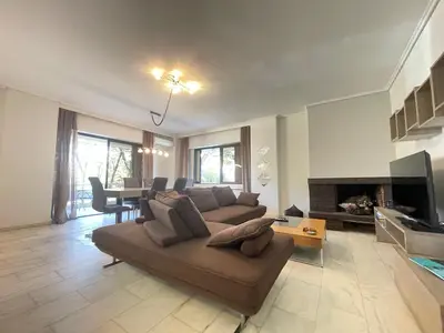 a living room with a couch and a table at Aries - Glyfada City Center Apartment in Athens