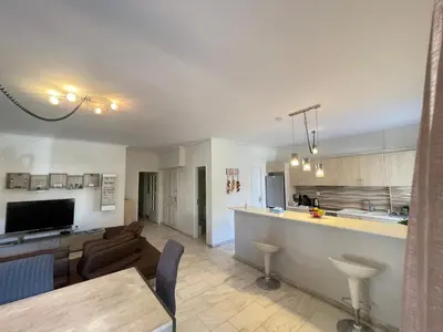 a kitchen and living room with a couch and a table at Aries - Glyfada City Center Apartment in Athens