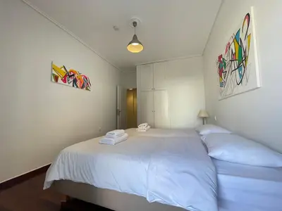 a bedroom with a large white bed with two pillows at Aries - Glyfada City Center Apartment in Athens
