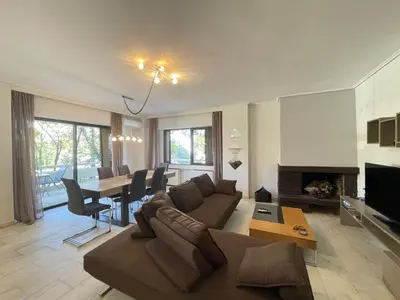 a living room with a couch and a table at Aries - Glyfada City Center Apartment in Athens