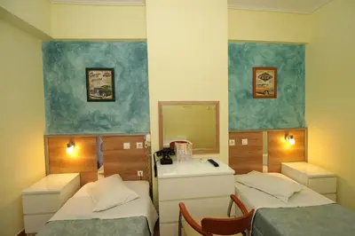 a small room with two beds and a mirror at Socrates Hotel in Athens