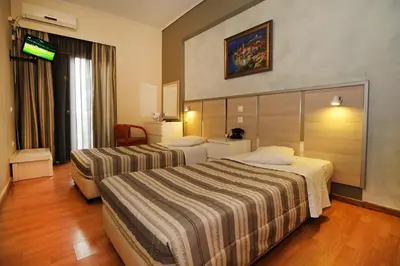 a hotel room with two beds and a television at Socrates Hotel in Athens