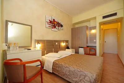 a hotel room with a bed and chairs and a mirror at Socrates Hotel in Athens