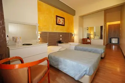 a hotel room with two beds and a kitchen at Socrates Hotel in Athens