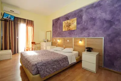 a bedroom with a large bed and a purple wall at Socrates Hotel in Athens