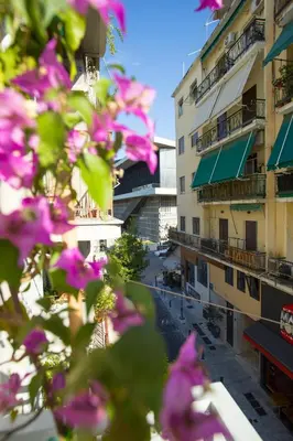 a bunch of pink flowers in front of buildings at Acropolis Museum - Modern Living [II] in Athens