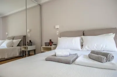 a bedroom with a white bed with towels on it at Acropolis Museum - Modern Living [II] in Athens