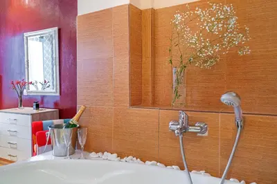 a bathroom with a tub with a vase on the wall at Zen Hotel in Athens
