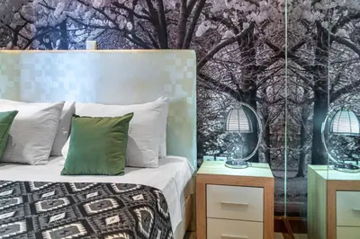 a bedroom with a bed and a tree mural at Zen Hotel in Athens