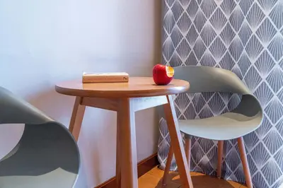 a small table with an apple on it next to two chairs at Zen Hotel in Athens