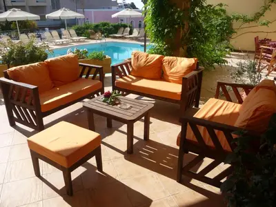 a group of chairs and tables next to a pool at Hotel Afea in Agia Marina Aegina