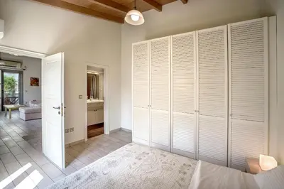 a bedroom with white closet doors and a bathroom at Valashouse in Athens