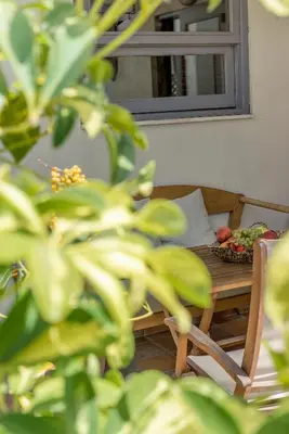 a table and a chair with a bowl of fruit on it at Valashouse in Athens