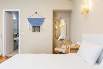 a bedroom with a white bed and a mirror at Kolonaki Suites by Olala Homes in Athens