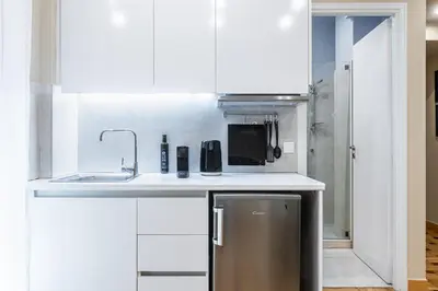 a kitchen with white cabinets and a sink at Kolonaki Suites by Olala Homes in Athens