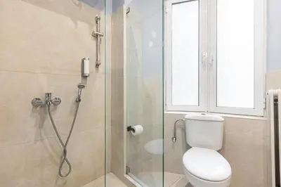 a bathroom with a toilet and a glass shower at Kolonaki Suites by Olala Homes in Athens