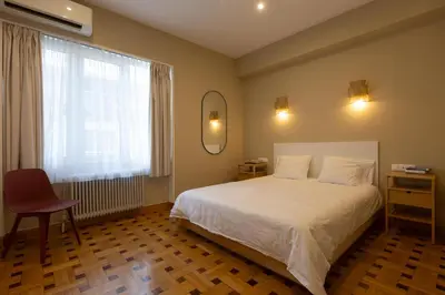 a bedroom with a white bed and a window at Kolonaki Suites by Olala Homes in Athens