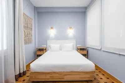 a bedroom with a white bed with two night stands at Kolonaki Suites by Olala Homes in Athens