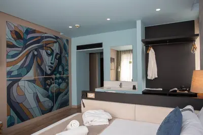 a bedroom with a large painting on the wall at Casual Kubic Athens in Athens
