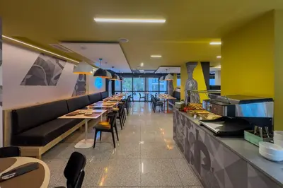 a restaurant with a long counter with tables and chairs at Casual Kubic Athens in Athens