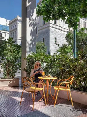 a woman sitting at a table with a cup of coffee at Casual Kubic Athens in Athens