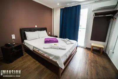 a bedroom with a bed with two towels on it at Mansion Hotel in Athens