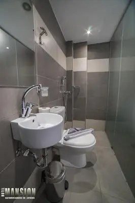 a bathroom with a sink and a toilet at Mansion Hotel in Athens